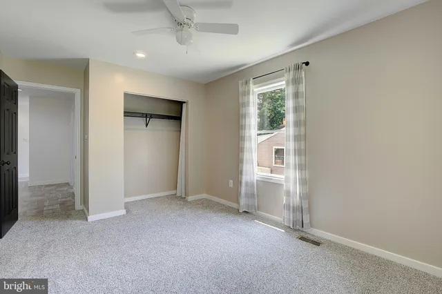an empty room with windows and cabinet