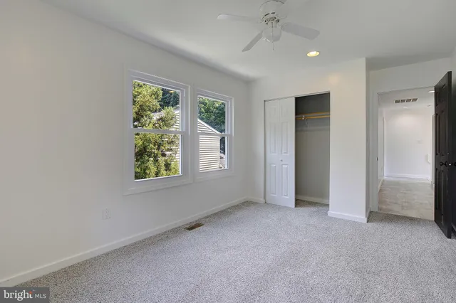 an empty room with windows and closet