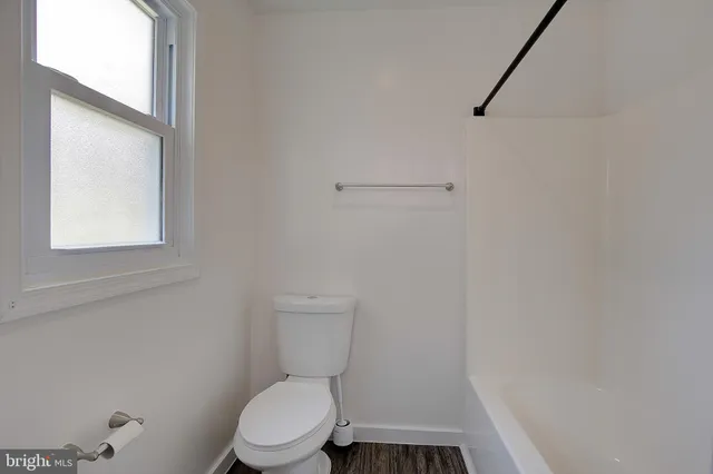 a white toilet sitting next to a white sink and vanity