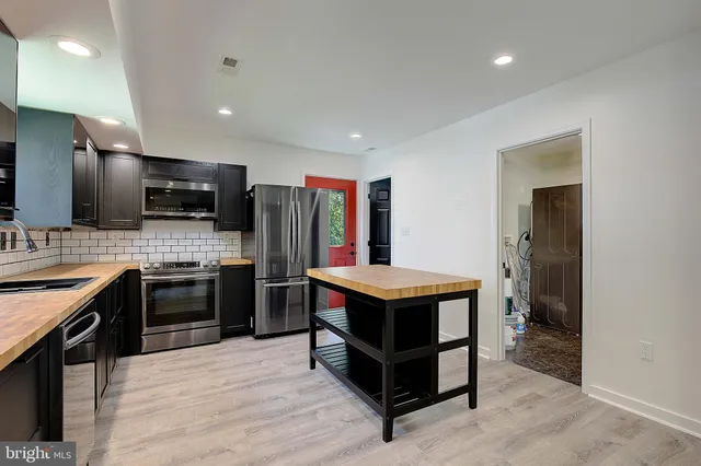 a kitchen with stainless steel appliances a stove a sink dishwasher a refrigerator and a oven