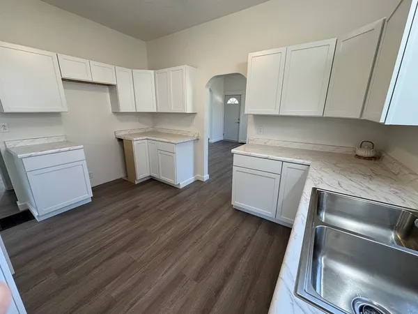 a view of a kitchen with wooden floor and electronic appliances