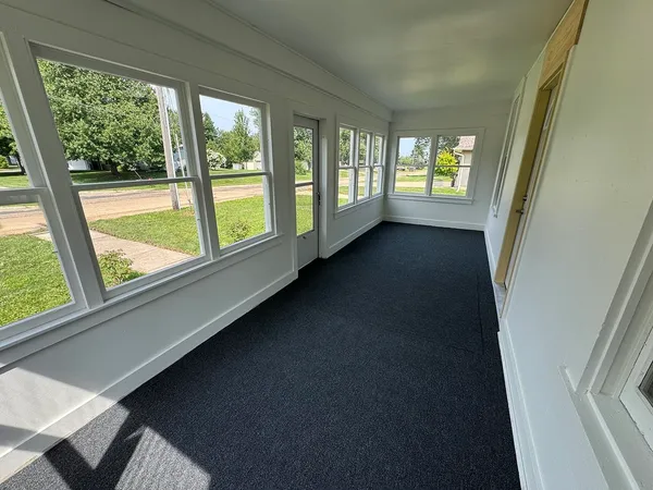 an empty room with windows and fan