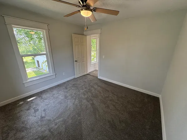 an empty room with windows and closet