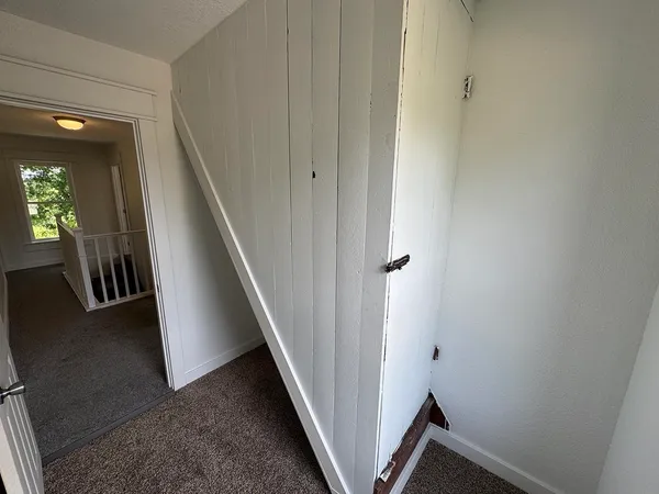 a view of an empty room with a fireplace and a window