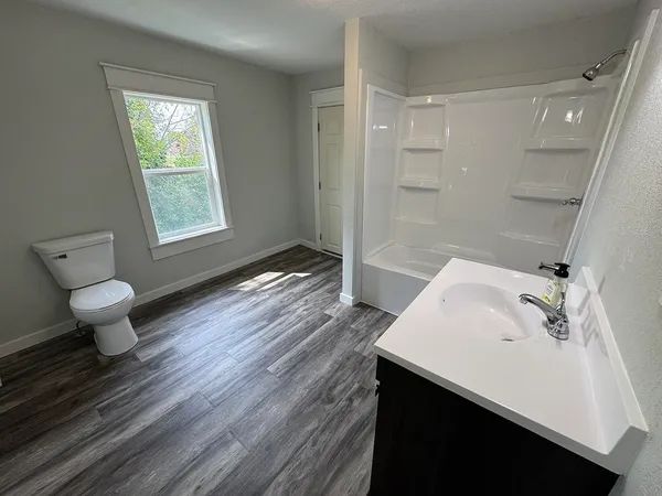a bathroom with a toilet sink mirror and vanity