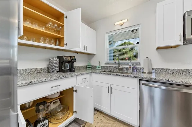 a kitchen with granite countertop stainless steel appliances a sink and cabinets
