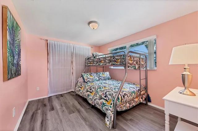 a bedroom with bed wooden floor and lamp