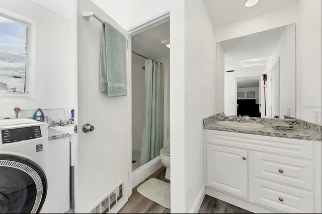 a bathroom with a granite countertop sink and a mirror