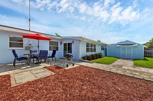 a patio with a table and chairs and potted plants