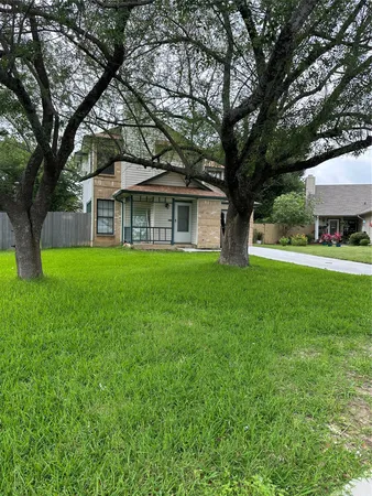 a front view of a house with yard and green space