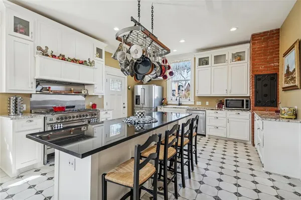 a kitchen with granite countertop a sink appliances cabinets and counter space