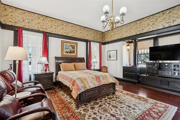 a spacious bedroom with a bed and a flat screen tv