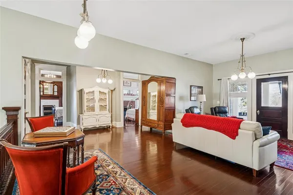 a living room with furniture a chandelier and a dining table