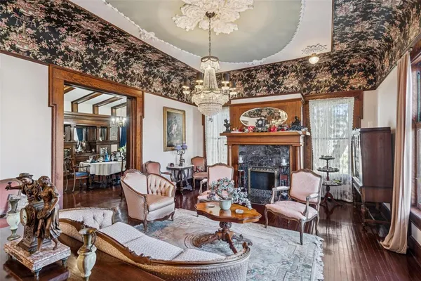 a living room with furniture a fireplace and a chandelier