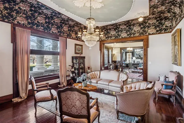 a living room with furniture a chandelier and a large window