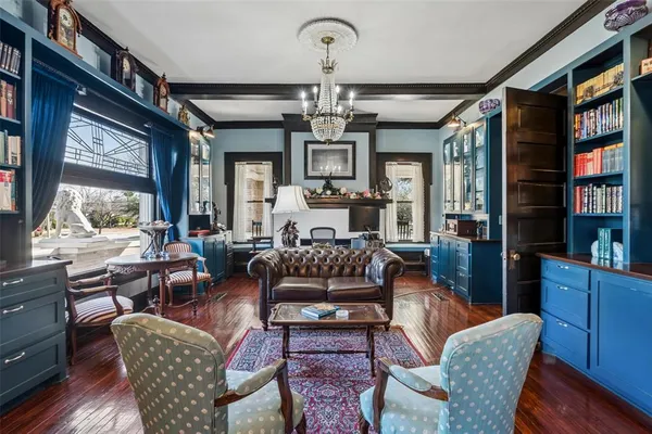 a living room with furniture a chandelier and a large window