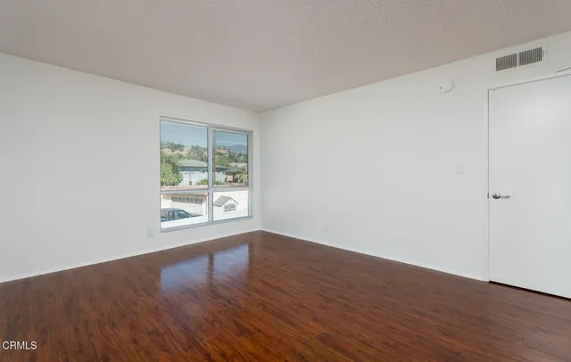 a bedroom with a bed and a table in it next to a window