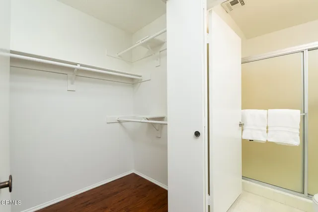 a hallway with wooden floor and a potted plant