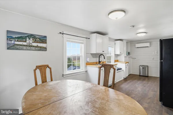 a kitchen with a refrigerator and a wooden floor
