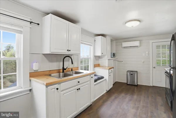 a kitchen with white cabinets and sink