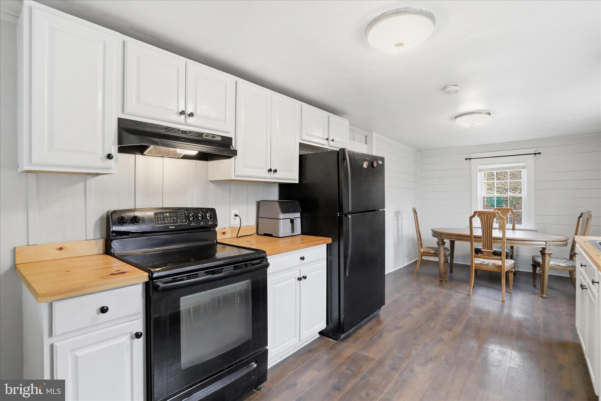 277 Bowmans Ridge Lane Burlington, WV 26710 - Photo 10 of 42 a kitchen with a stove a refrigerator and a dining table