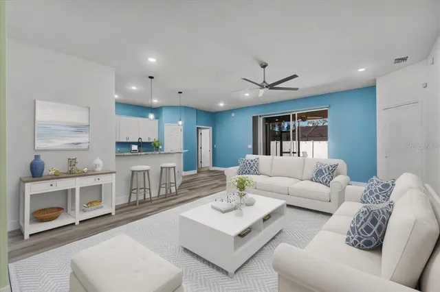 a living room with furniture white walls and kitchen view