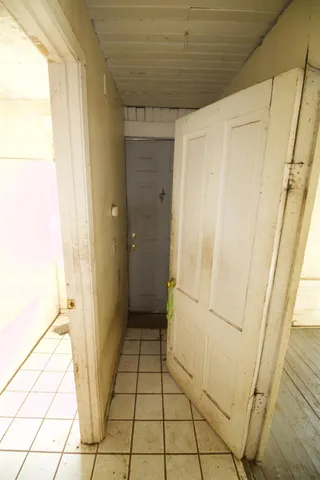 a view of a hallway with white walls and stairs