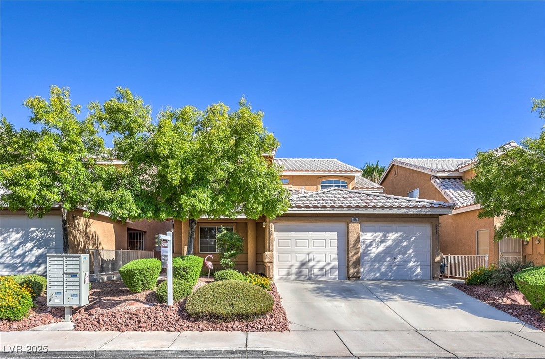 View of front of home featuring stucco siding, concrete driveway, and a garage