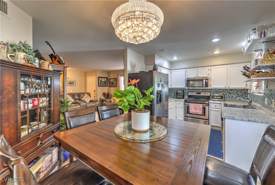 8056 Cimarron Ridge Drive, Unit 101 Las Vegas, NV 89128 - Photo 19 of 31 Dining area with a chandelier