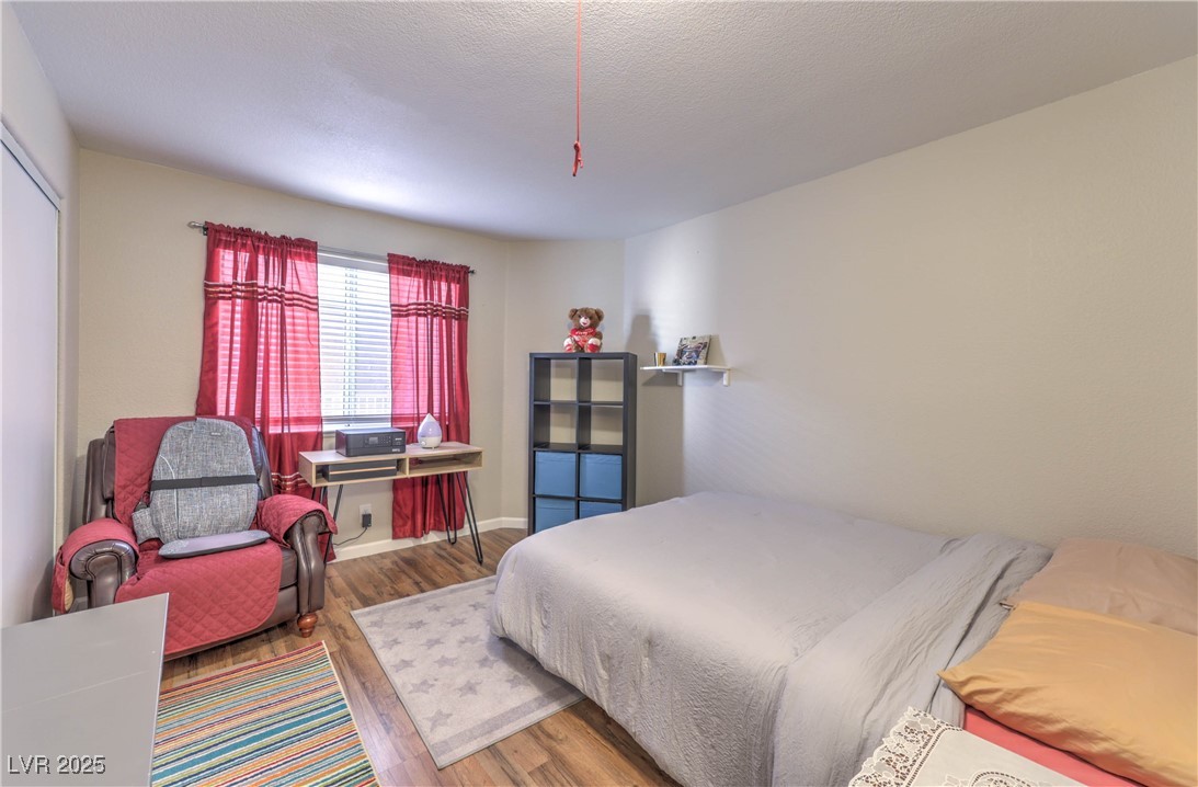 8056 Cimarron Ridge Drive, Unit 101 Las Vegas, NV 89128 - Photo 20 of 31 Bedroom with wood finished floors and a textured ceiling
