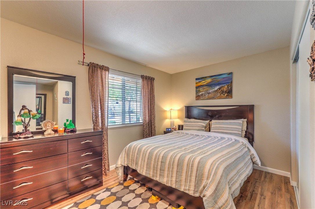 8056 Cimarron Ridge Drive, Unit 101 Las Vegas, NV 89128 - Photo 21 of 31 Bedroom with light wood-style flooring and baseboards