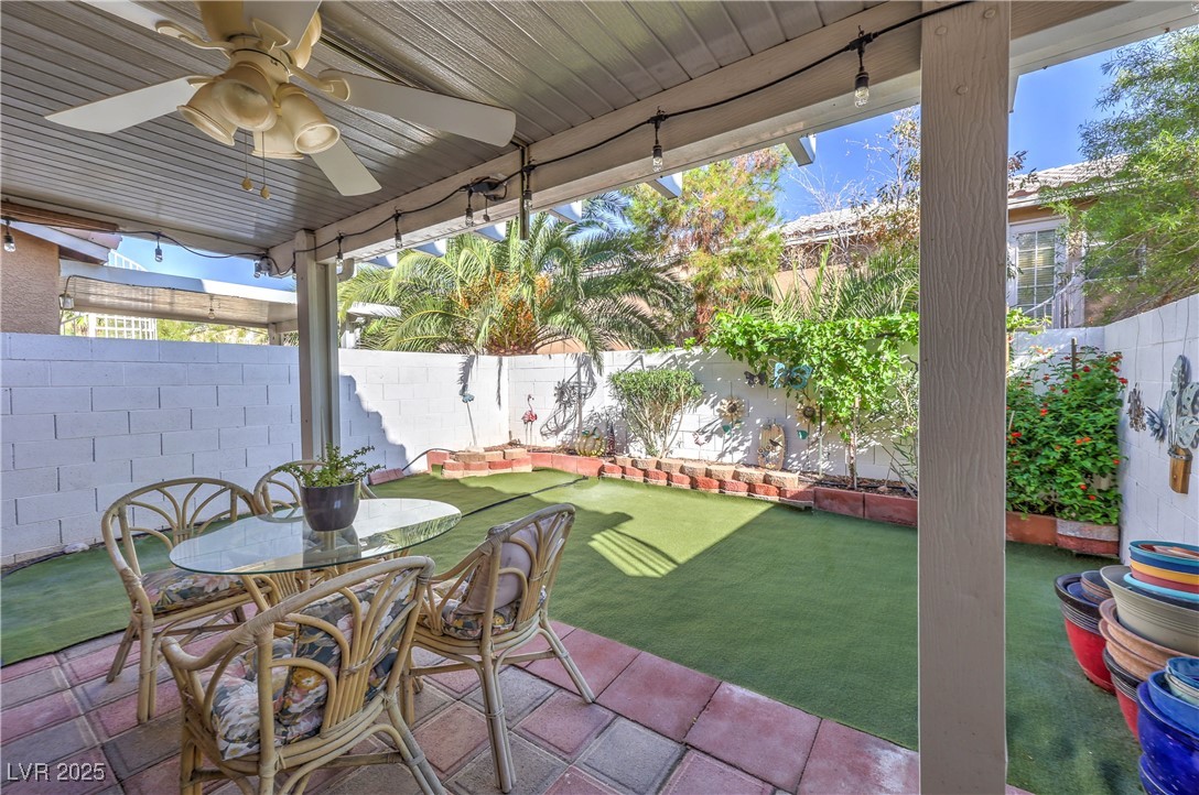 8056 Cimarron Ridge Drive, Unit 101 Las Vegas, NV 89128 - Photo 27 of 31 Fenced backyard featuring a ceiling fan and a patio