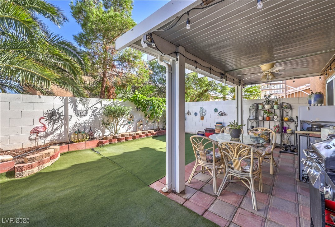 8056 Cimarron Ridge Drive, Unit 101 Las Vegas, NV 89128 - Photo 28 of 31 Fenced backyard with a patio area, area for grilling, and a ceiling fan