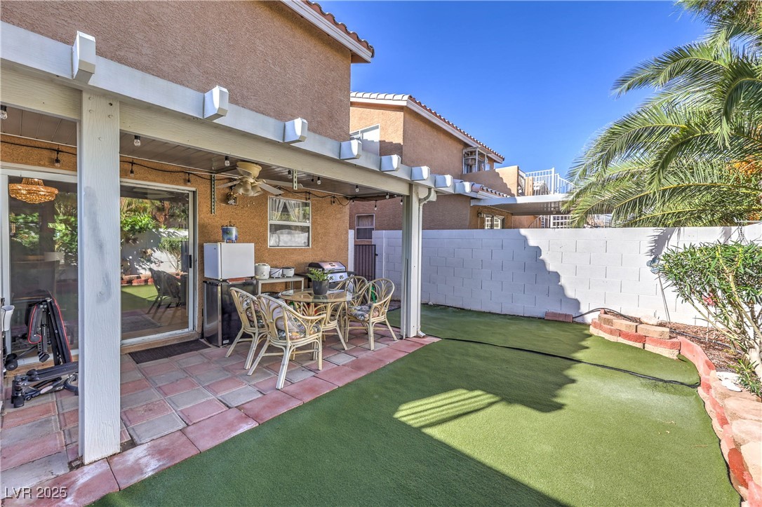 8056 Cimarron Ridge Drive, Unit 101 Las Vegas, NV 89128 - Photo 29 of 31 Fenced backyard featuring a patio and a ceiling fan
