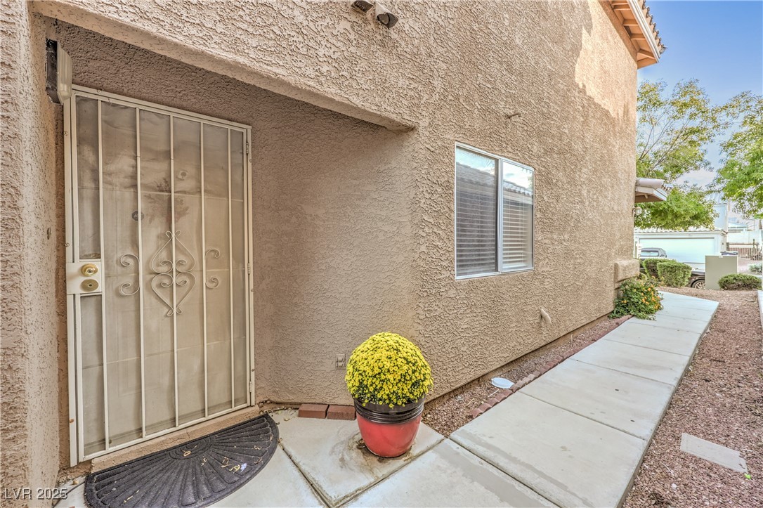 8056 Cimarron Ridge Drive, Unit 101 Las Vegas, NV 89128 - Photo 4 of 31 View of exterior entry with stucco siding