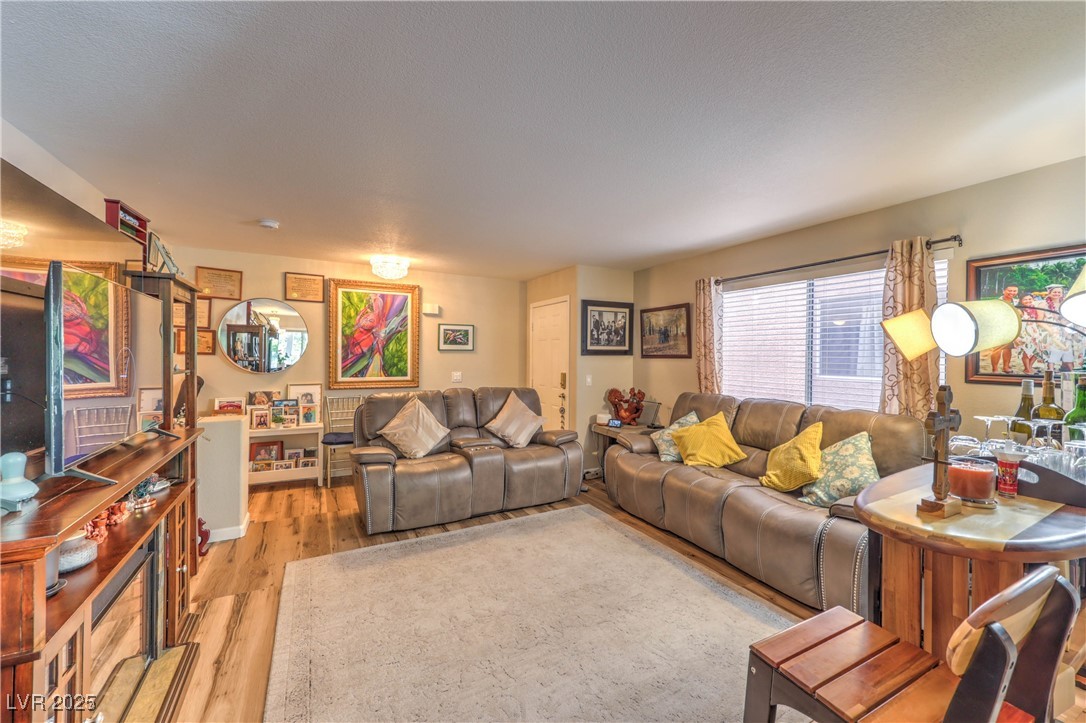8056 Cimarron Ridge Drive, Unit 101 Las Vegas, NV 89128 - Photo 5 of 31 Living room featuring wood finished floors
