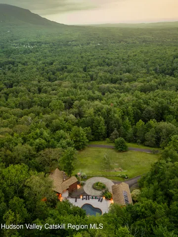 a backyard of a house with table and chairs under an umbrella