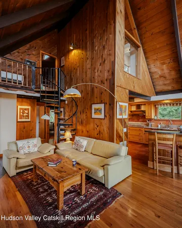 a living room with furniture a flat screen tv and kitchen view