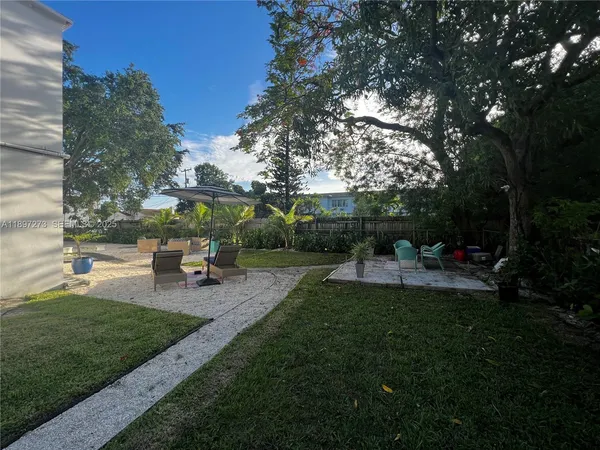 a view of a patio with plants and chairs
