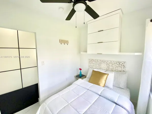 a bedroom with furniture and a large window