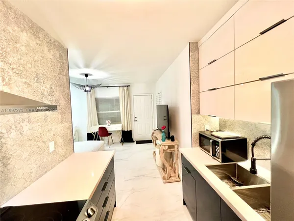 a kitchen with stainless steel appliances kitchen island granite countertop a refrigerator a stove and a sink with granite countertops