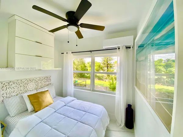 a bedroom with a bed and a large window