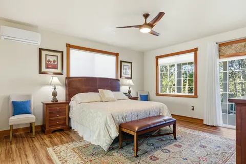 a bedroom with a bed wooden floor and a table