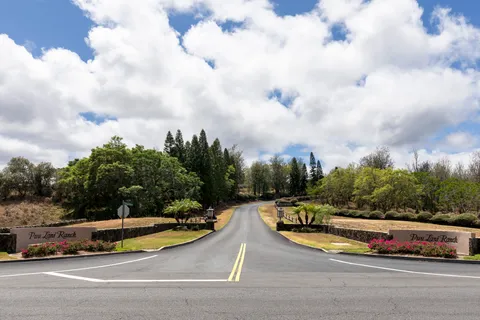 a view of swimming pool with outdoor seating and trees in the background