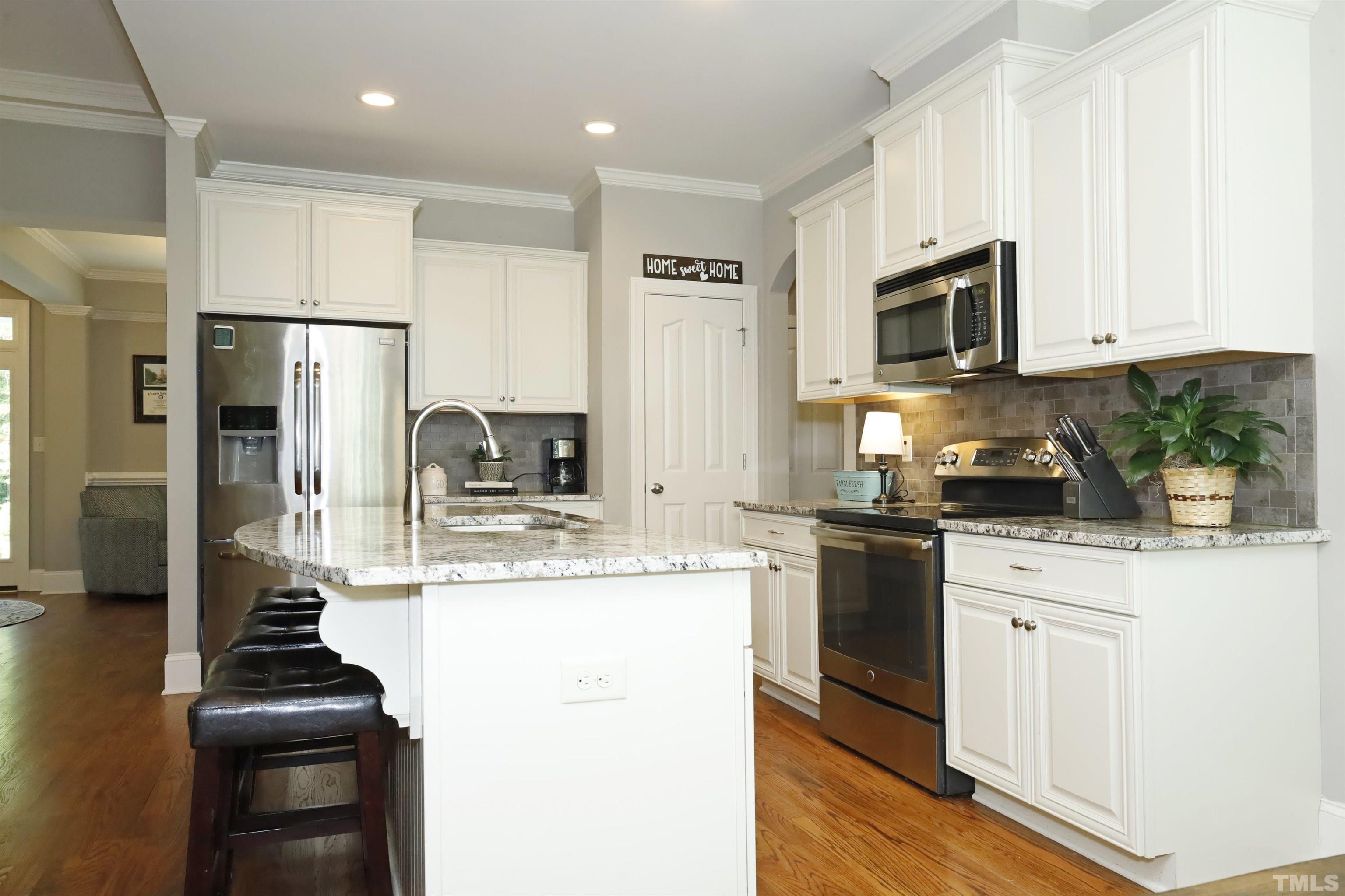 3630 Pine Needles Drive Wake Forest, NC 27587 - Photo 15 of 47 a kitchen with stainless steel appliances kitchen island granite countertop a stove a sink and a refrigerator