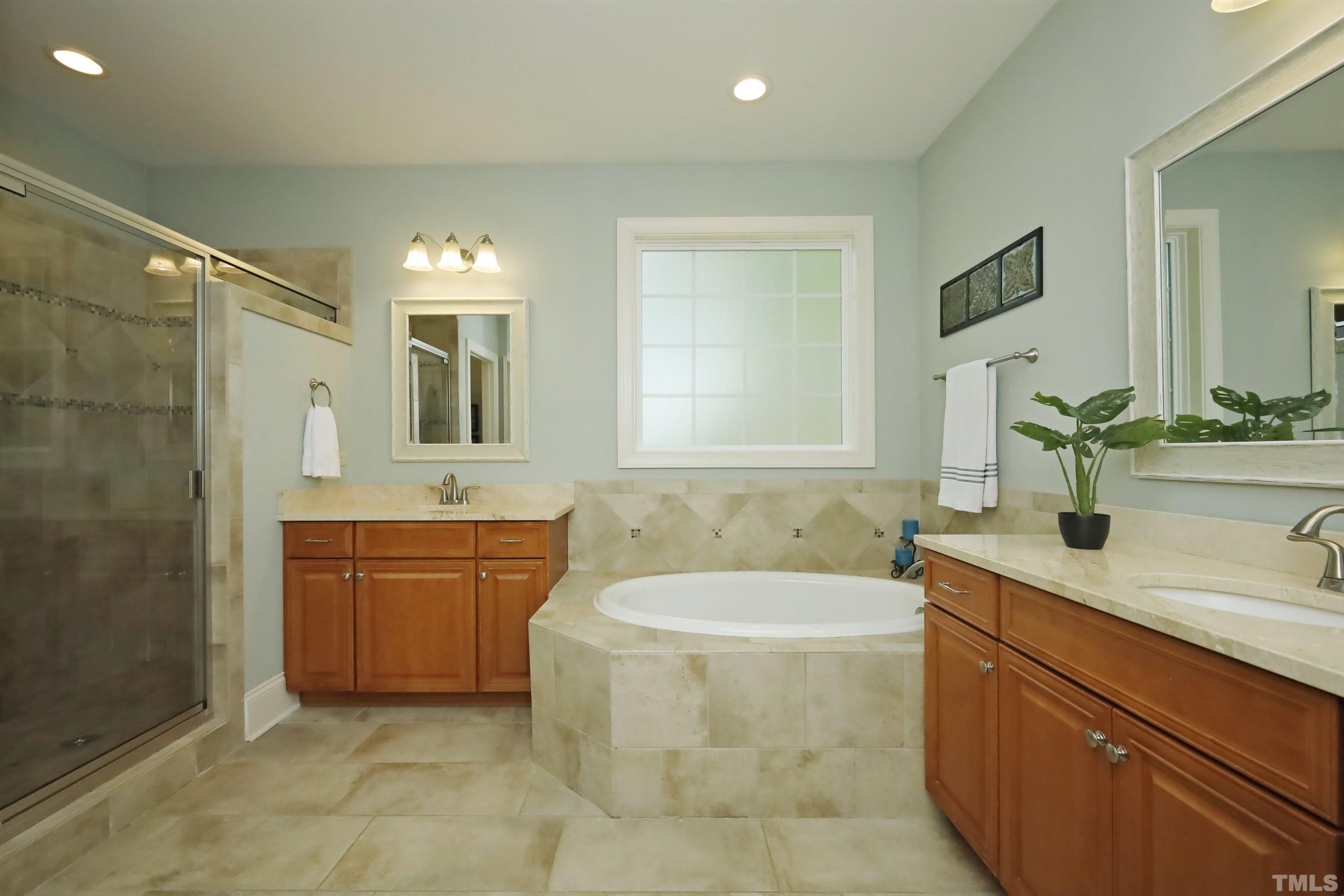 3630 Pine Needles Drive Wake Forest, NC 27587 - Photo 25 of 47 a bathroom with a granite countertop bathtub sink and mirror
