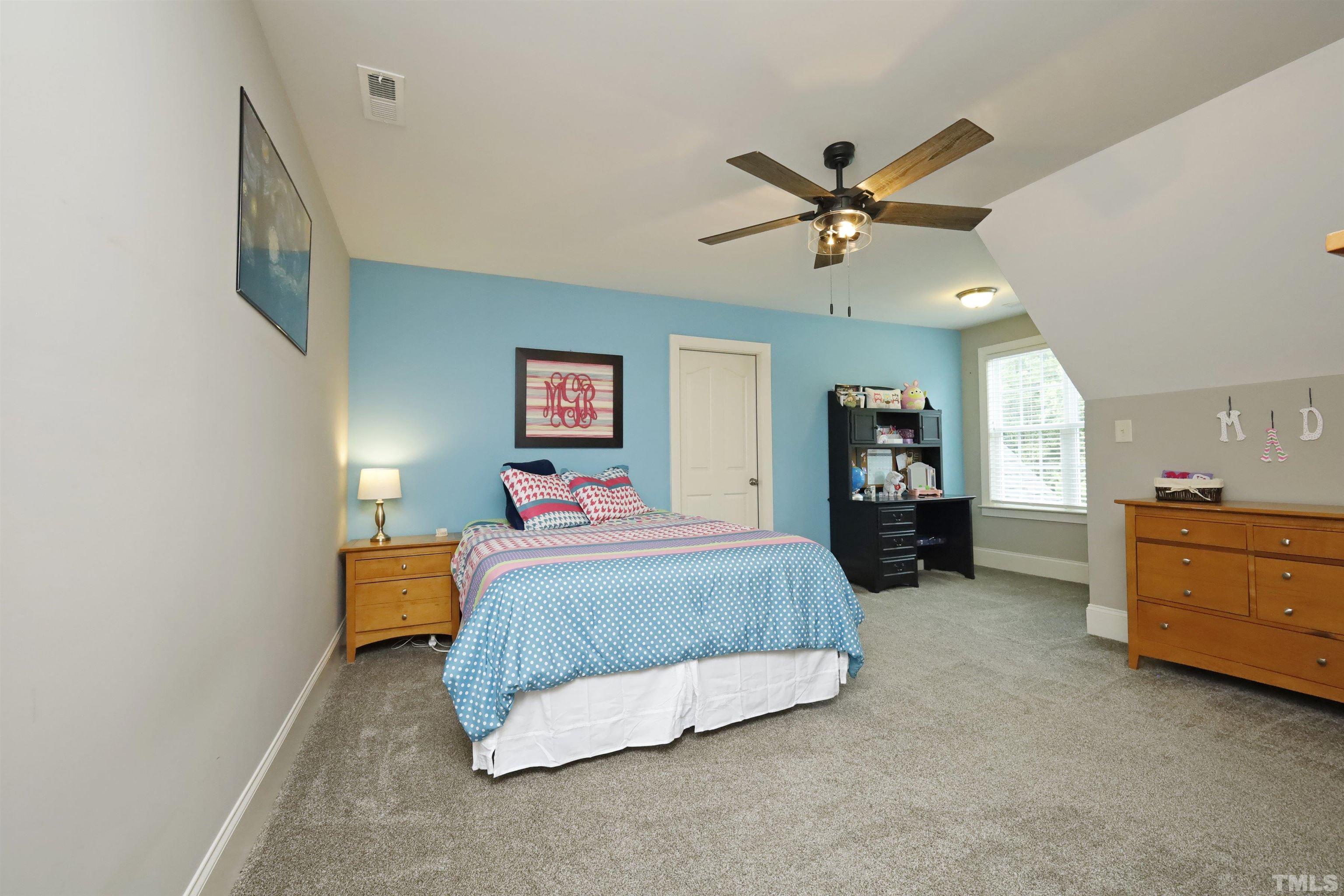 3630 Pine Needles Drive Wake Forest, NC 27587 - Photo 32 of 47 a spacious bedroom with a bed a dresser and a chandelier