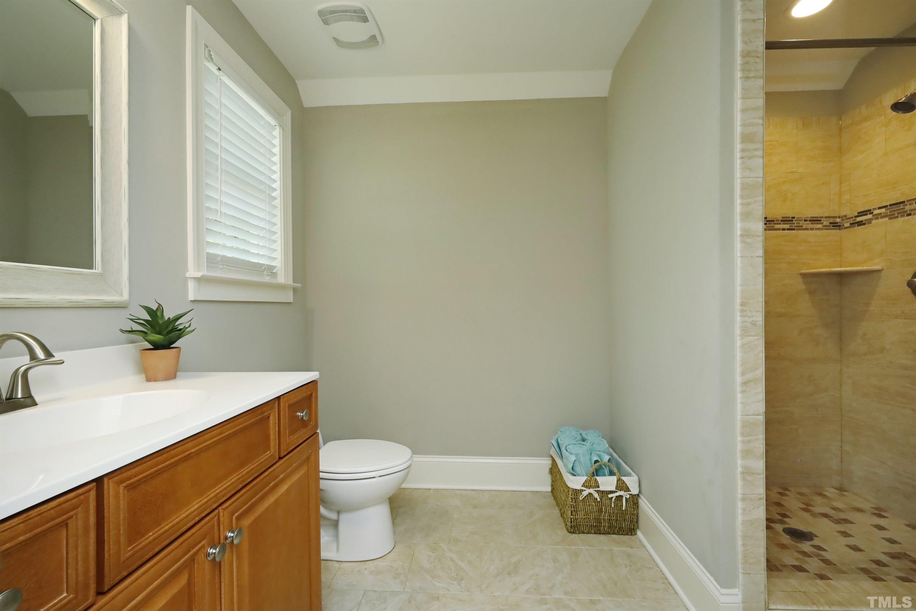 3630 Pine Needles Drive Wake Forest, NC 27587 - Photo 34 of 47 a bathroom with a granite countertop toilet a sink and a mirror