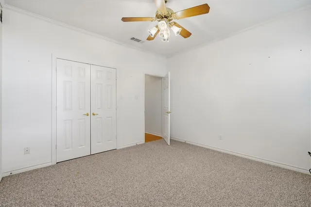 an empty room with a window and a ceiling fan