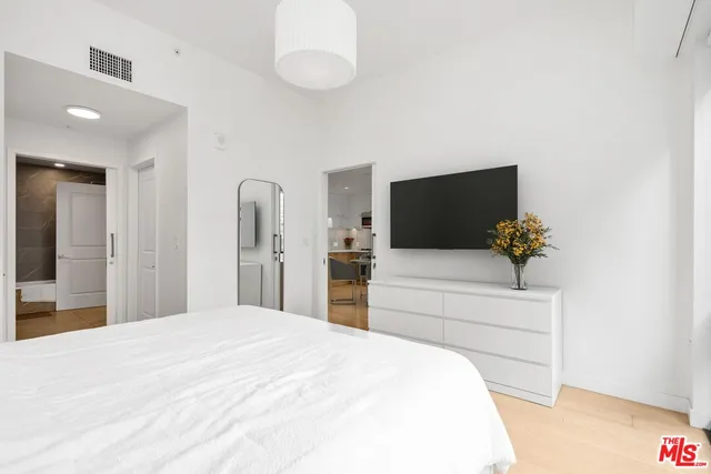 a bedroom with a bed and a flat screen tv